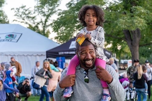 Little girl from the Cornwall consolidated school on a smiling man's shoulders