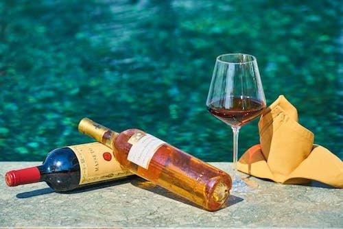 Bottles of wine sitting by one of the outdoor pools of a romantic getaway in Rhode Island