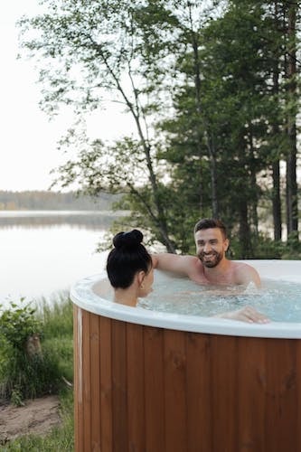 Couple enjoying a hot tub by a lake at one of the best resorts in CT