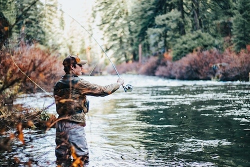 Man on a fly fishing trip, enjoying a quiet moment
