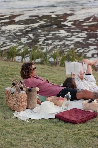 Couple enjoying a delicious picnic by the water on a relaxing evening together