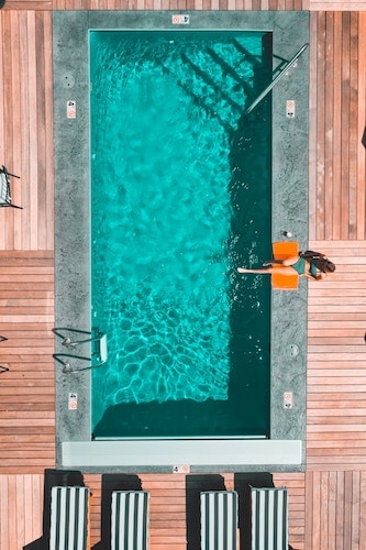 Woman relaxing by one of the many outdoor pools on this list