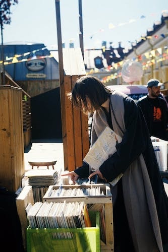 Woman sifting through vinyl records at Elephant's Trunk Flea Market in New Milford CT