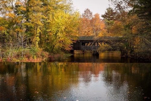 Fall along a New England dam and covered bridge, an autumn walk is one of the best things to do in Sturbridge MA