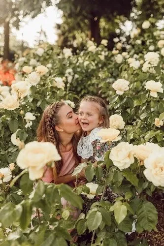 Mother and child joining families in having the time of their life in a rose garden