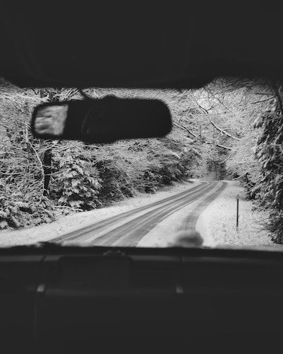 Driving a wintery road on one of the best New England road trips
