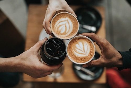 Friends cheering with various espresso blends and iced teas from a back country market