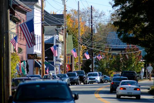 A line of cars passing through one of the picturesque towns on the way to the Finger Lakes region