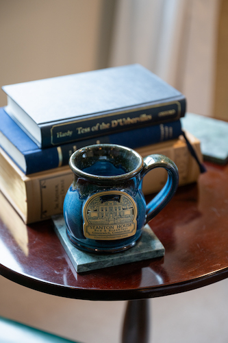 Mug and books on a side table in the lounge area of Room 14