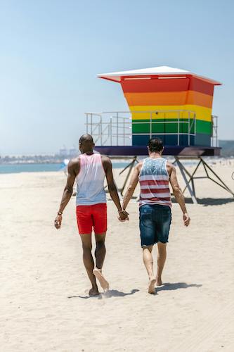 Gay men walking down a beach together