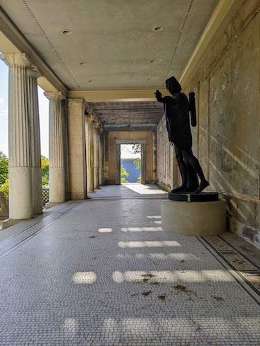 Statue pointing away from the door leading to the vista