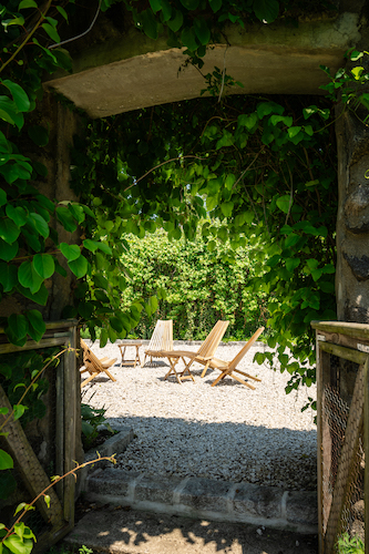 Lounge chairs amidst the ruins of the gardens at Stanton House Inn in summer
